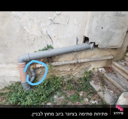 צינור מתכת עם חיבורי פלסטיק על קיר חיצוני